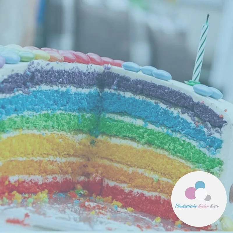 Angeschnittene Regenbogentorte mit bunten Schichten und einer Kerze
